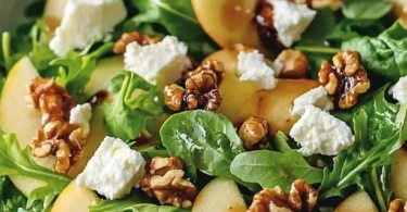 Frischer Apfel-Walnuss-Salat mit Äpfeln und Walnüssen auf einem Teller angerichtet.