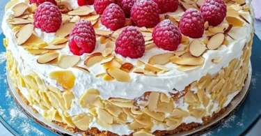 Himmelstorte mit frischen Himbeeren auf einem weißen Teller
