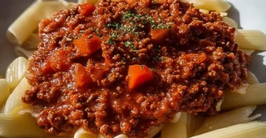 Schüssel mit frisch zubereiteter Bolognesesauce auf einem Holztisch