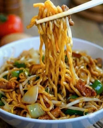 Schüssel mit frisch zubereiteten Chinesischen Nudeln in einer aromatischen Sauce.