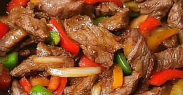 Chinesisches Rindfleisch mit Zwiebeln und Paprika auf einem Teller serviert
