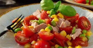 Leichter Thunfisch-Tomate-Salat auf einem Teller, angerichtet mit frischen Zutaten.