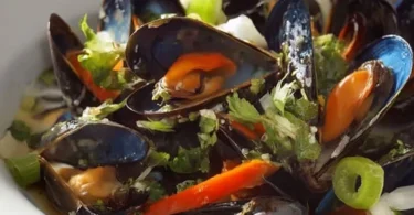 Delizioso Gericht von Muscheln in Weißwein serviert in einer Schüssel.