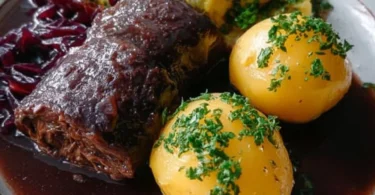 Delikate Rinderrouladen in Rotwein auf einem eleganten Teller serviert.