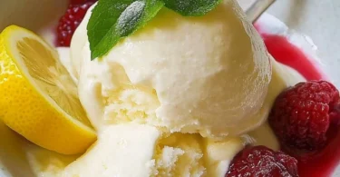 Zitronenfroyo-Eis in einer Servierschale mit frischen Zitronenscheiben