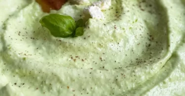 Avocado-Feta-Dip in einer Schale mit frischem Brot und Gemüse