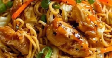 Chinesisch gebratene Nudeln mit Hühnerfleisch auf einem Teller serviert.