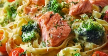 Cremige Pasta mit Lachs, Brokkoli und Tomaten in einer weißen Schale