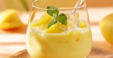 Eierlikörbowle mit Ananas und Sekt in einem Glas serviert.