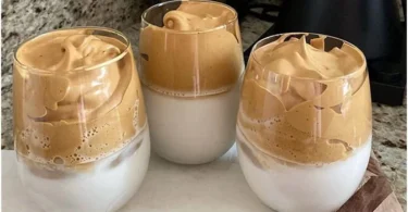 Erfrischender Eiskaffee mit Sahne und Eiswürfeln in einem Glas.