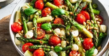 Grüner Spargel Salat mit Tomaten und Mozzarella in einer Schüssel
