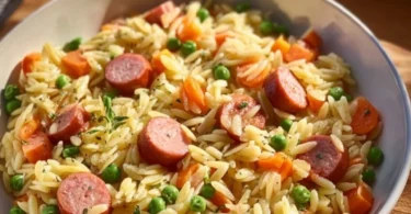 Kritharaki Pan mit Würstchen auf einem Teller serviert