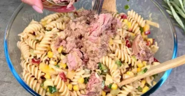 Leckere Thunfisch-Pasta-Salat in einer bunten Schüssel serviert.