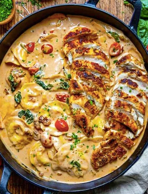 Tortellini in Hähnchen-Schmand auf einem Teller serviert