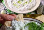 Schüssel mit frischem Tzatziki, einem traditionellen griechischen Joghurt-Dip mit Gurken und Knoblauch.