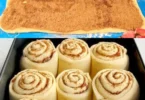 Frisch gebackene Zimtschnecken auf einem Teller, dekoriert mit Zuckerguss