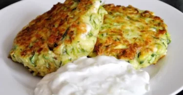 Leckere Zucchini-Feta-Puffer auf einem Teller serviert.