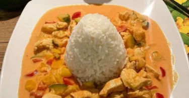 Paprika-Zucchini-Sahne Hühnchen serviert mit dampfendem Reis