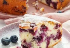 Saftiger Blaubeerkuchen mit Joghurt auf einem dekorativen Teller serviert.