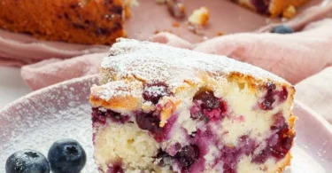 Saftiger Blaubeerkuchen mit Joghurt auf einem dekorativen Teller serviert.