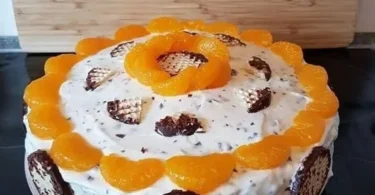Schokoladenkuss-Mandarinen-Kuchen auf einem Teller garniert mit Mandarinen und Schokolade.