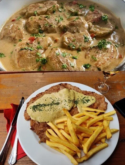 Schweineschnitzel mit Sahnesauce und Reis auf einem Teller serviert