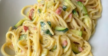 Zucchini Carbonara mit Nudeln und frischen Zutaten auf einem Teller