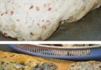 Zwiebel-Käse-Brot mit Schinken, frisch gebacken und serviert auf einem Holzbrett.