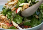 Schüssel mit Apfel-Walnuss-Salat, frisch zubereitet mit knackigen Äpfeln und Walnüssen.
