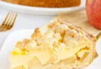 Apfelkuchen mit Vanillepudding auf einem Teller serviert.