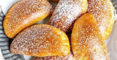 Apfeltaschen mit Quark-Öl-Teig auf einem rustikalen Holzbrett