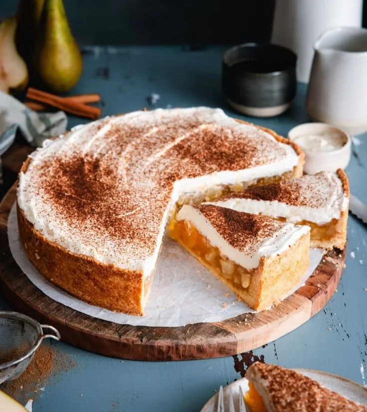 Birnenkuchen mit Schmandcreme auf einem Teller serviert