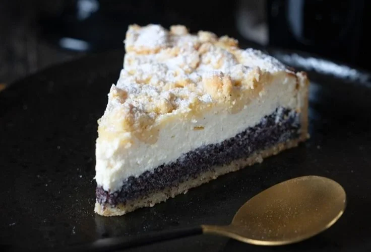 Cremiger Käsekuchen mit Mohnfüllung und Streuseln auf einem Teller