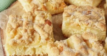 Einfacher Apfelkuchen vom Blech mit Streuseln auf einem rustikalen Tisch.