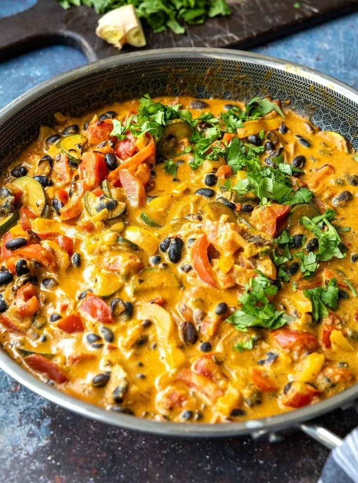 Gemüse-Curry mit schwarzen Bohnen auf einem bunten Teller serviert