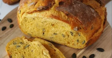 herbstliches Kürbisbrot mit Gewürzen und Kürbiskernen auf einem Holzbrett