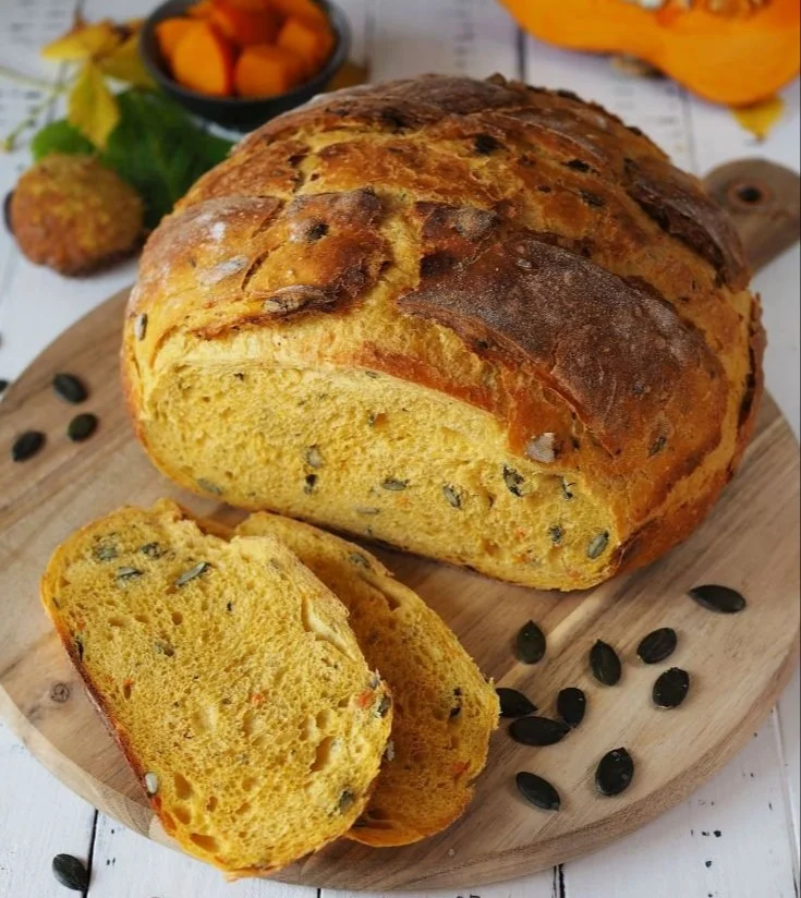 herbstliches Kürbisbrot mit Gewürzen und Kürbiskernen auf einem Holzbrett