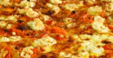 Kürbis-Quiche mit Feta auf einem Holzbrett serviert