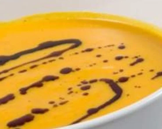Vegane Kürbissuppe mit Kokosmilch, sämig und lecker serviert in einer Schüssel.