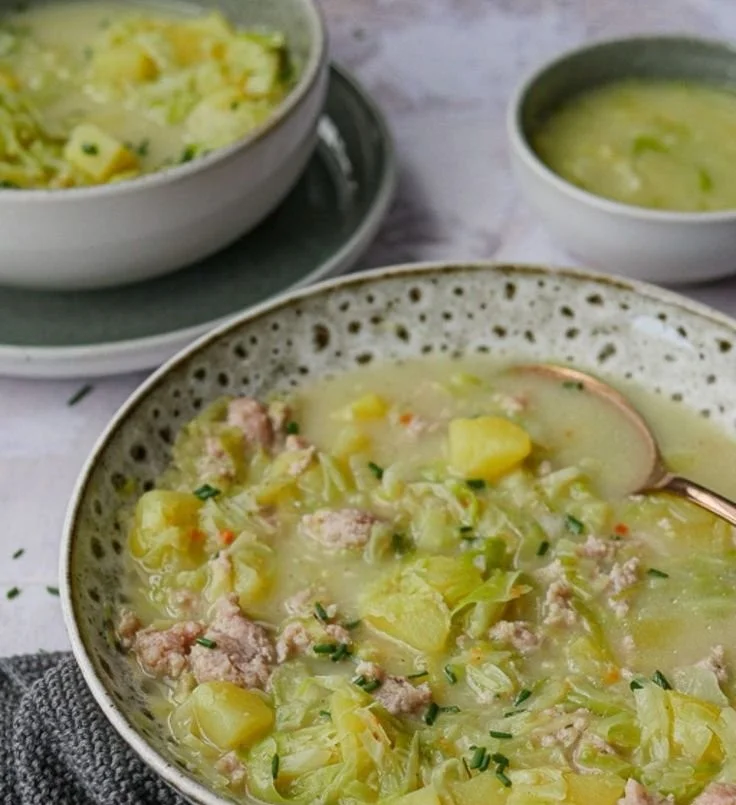 Wärmende Spitzkohlsuppe mit frischen Zutaten in einer Schüssel serviert.