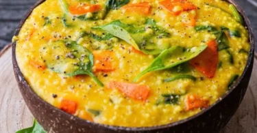 One Pot Hirse mit Kürbis und Spinat in einer bunten Schüssel serviert.