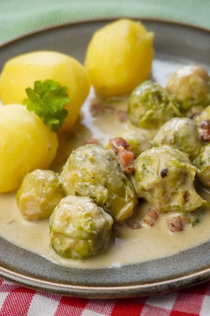 Rahm-Rosenkohl mit Speck in einer cremigen weißen Soße serviert.