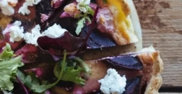 Rote-Bete-Quiche frisch aus dem Ofen mit buntem Gemüse garniert