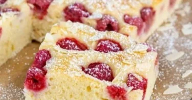 Schneller Himbeerkuchen auf einem Teller mit frischen Himbeeren