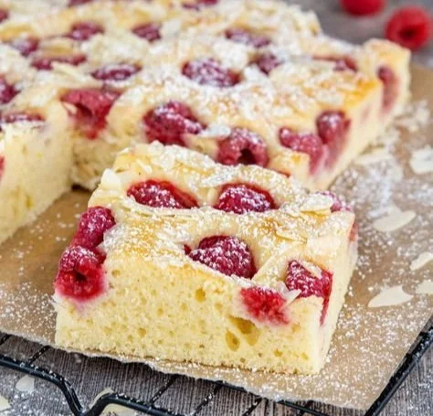 Schneller Himbeerkuchen auf einem Teller mit frischen Himbeeren