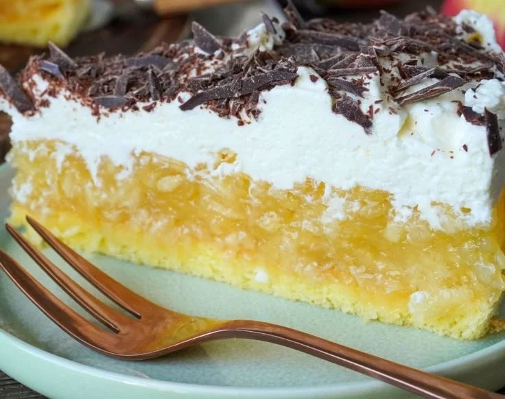 Schwedische Apfeltorte auf einem Holzbrett mit frischen Äpfeln dekoriert