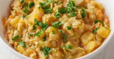 Spitzkohl mit Kartoffeln und roten Linsen auf einem Teller serviert