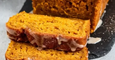 Veganer Kürbis Kuchen mit Zimt Glasur auf einem Teller, herbstliches Dessert.