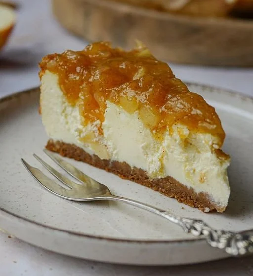 Weihnachtlicher Käsekuchen mit Spekulatiusboden und Bratapfel-Topping auf einem Teller